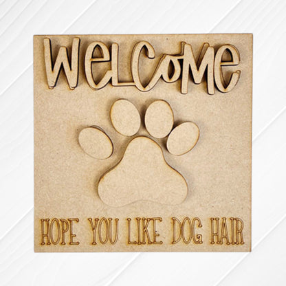 Dog Squares by Janet's Craft Corner features a wooden sign with "WELCOME" on top, a big paw print, and "HOPE YOU LIKE DOG HAIR" at the bottom—ideal for tiered tray decor or pairing with playful wood cut-outs.