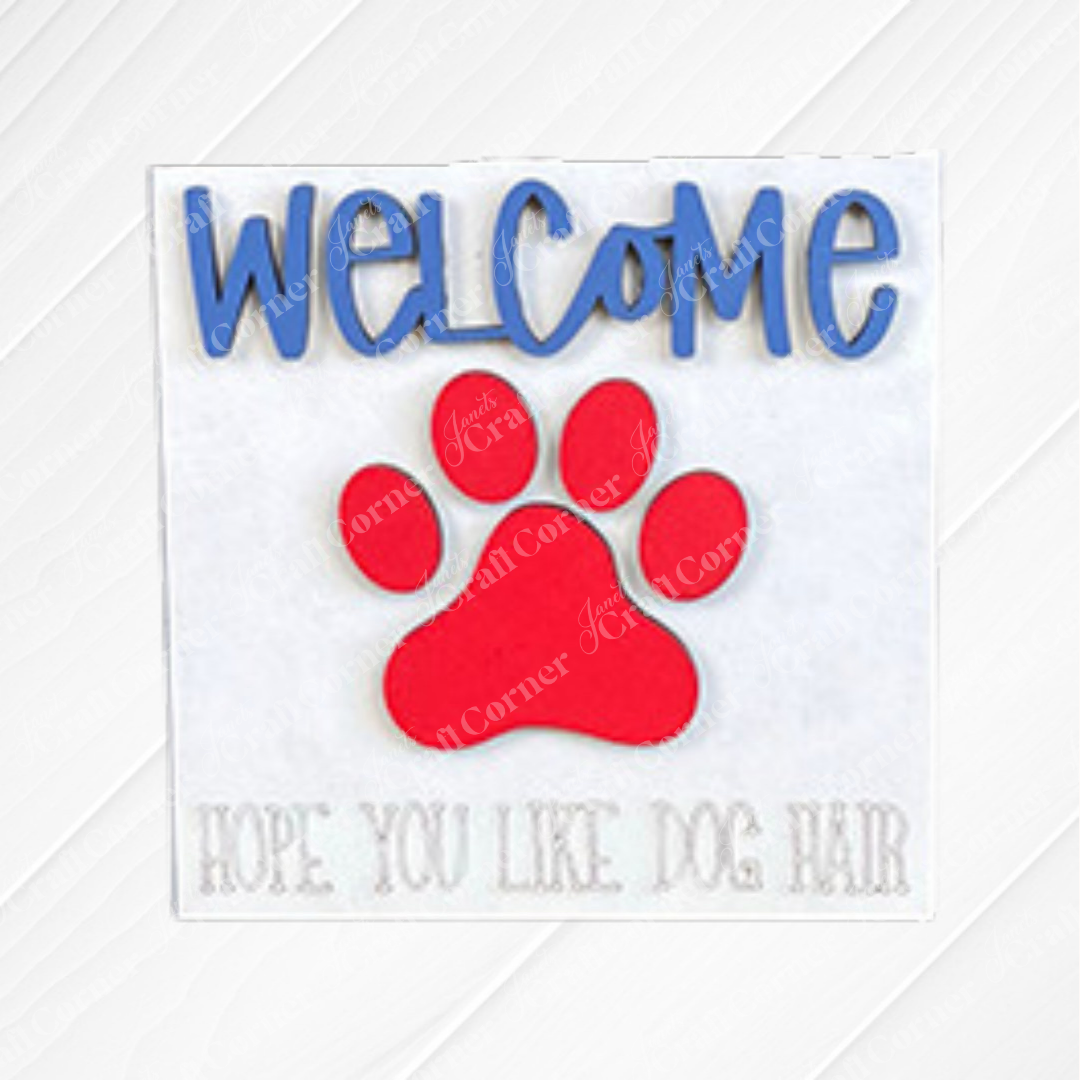 Add charm to your tiered tray with Janet's Craft Corner "Dog Squares"—a sign featuring blue "Welcome" text, a large red paw print, and gray "Hope you like dog hair," great alone or with swappable squares wood cut-outs.
