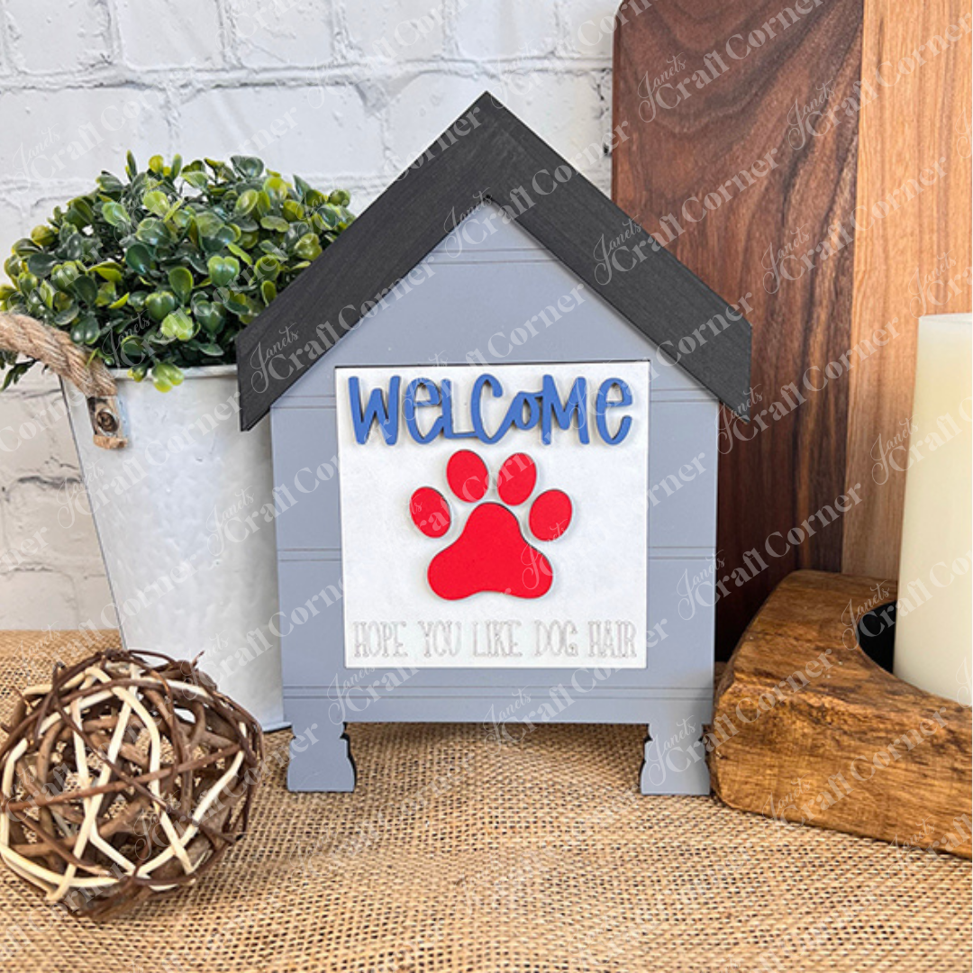 Janet's Craft Corner's Dog Squares features a doghouse-shaped sign reading "WELCOME" with a red paw print and "Hope you like dog hair"—ideal for tiered tray decor alongside plants, candles, or wicker accents.