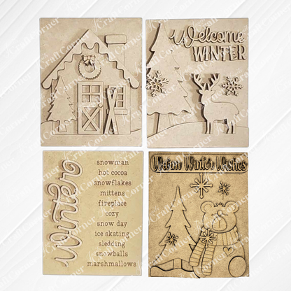 Displayed on a white wood backdrop are three winter-themed decorations: Janet's Craft Corner's Welcome Winter farmhouse signs featuring a deer, a polar bear, a list of winter words, and a house adorned with snow and skis. These items make for perfect home decor pieces.