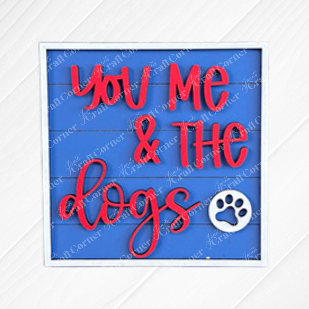 The Dog Squares sign from Janet's Craft Corner features "You Me & The dogs" in bold red on blue, accented with a white paw print—a charming accent for any tiered tray or to pair with wood cut-outs for a personal touch.
