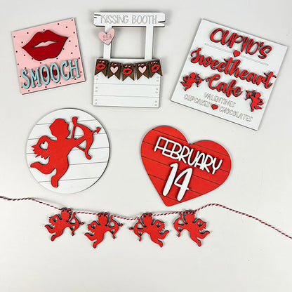 Create a charming Valentine's Day display with Janet's Craft Corner's "Cupid Kissing Booth Tiered Tray Kit." This set includes delightful red and white wooden signs such as lips with "Smooch," a "Cupid Kissing Booth," "Cupid’s Sweetheart Café," and a heart marked with "February 14." The kit also features cupid figures and a string of cupid ornaments, making it perfect for crafting an enchanting atmosphere or enhancing your DIY projects.