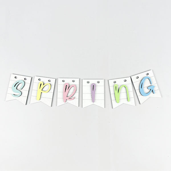 Enhance your tiered tray display with the Spring Truck Tiered Tray Kit from Janet's Craft Corner. It features a charming decorative banner that spells "SPRING" in pastel colors. Each letter is individually cut and affixed to a triangular pennant with two top holes on a white backdrop, making it perfect for your spring DIY decor project.