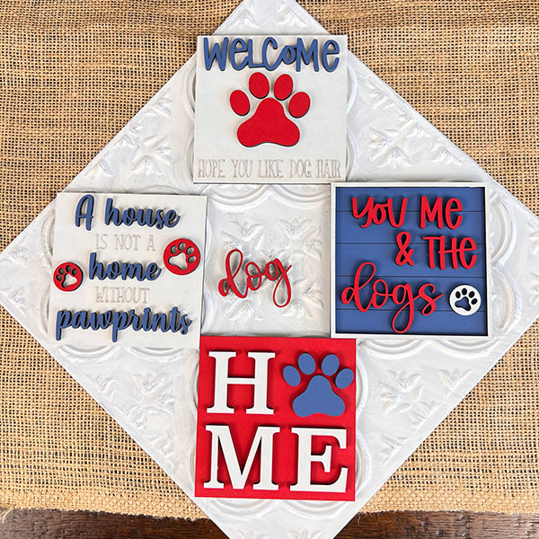 Introducing the "Dog Interchangeable Squares" by Janet's Craft Corner, a delightful set of four decorative dog-themed signs ideal for tiered trays. One sign welcomes guests with "WELCOME, hope you like dog hair" alongside a charming red paw print. The others feature heartwarming messages including "A house is not a home without pawprints," simply "dog," and "YOU, ME & the dogs," all adorned with lovely farmhouse accents and playful paw print graphics.