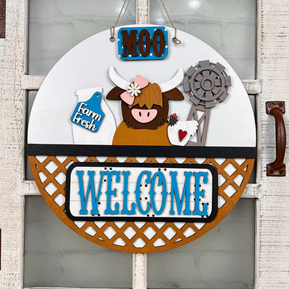 This Farm Welcome Interchangeable Insert from Janet's Craft Corner is a delightful addition to your DIY home décor kit. It showcases a round, rustic design with a cartoon highland cow adorned with a flower, alongside a windmill and "Farm Fresh" milk bottle. The words "MOO" above and "WELCOME" below are set against a lattice background, making it an ideal piece for your hand-painted crafts or as an interchangeable insert.