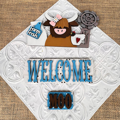 Add a touch of farmhouse charm to your home with the Farm Welcome Interchangeable Insert from Janet's Craft Corner. This DIY home decor kit features decorative signs on a textured background, including a hand-painted Highland cow accompanied by a "Farm Fresh" sign and gift, a "WELCOME" sign with bold blue letters, and an adorable smaller "MOO" sign. Perfect for farmhouse decor, it comes with interchangeable inserts for every season.
